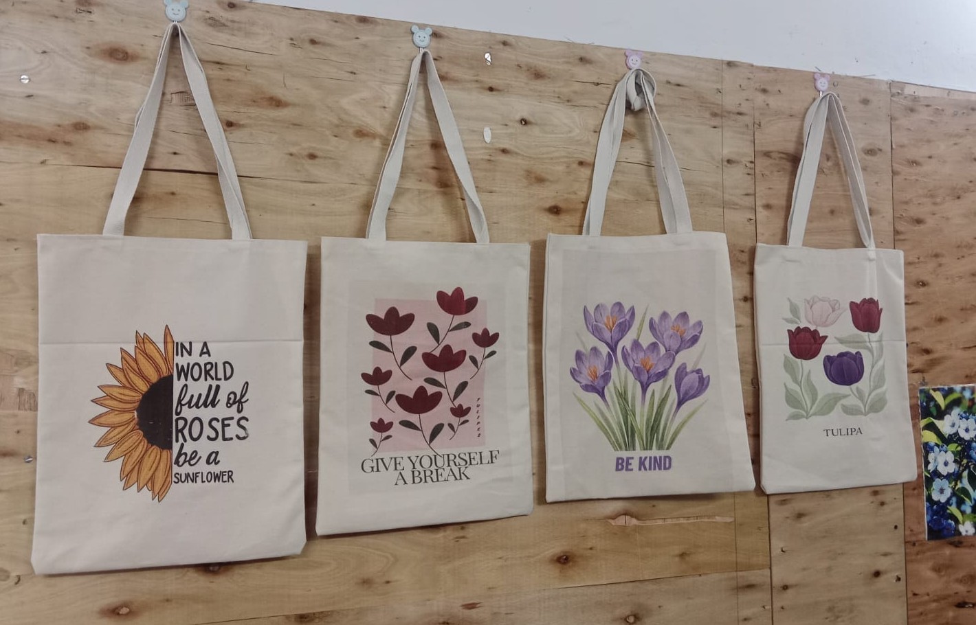 Printed cotton tote bags from Srima Fashion displayed on a wall